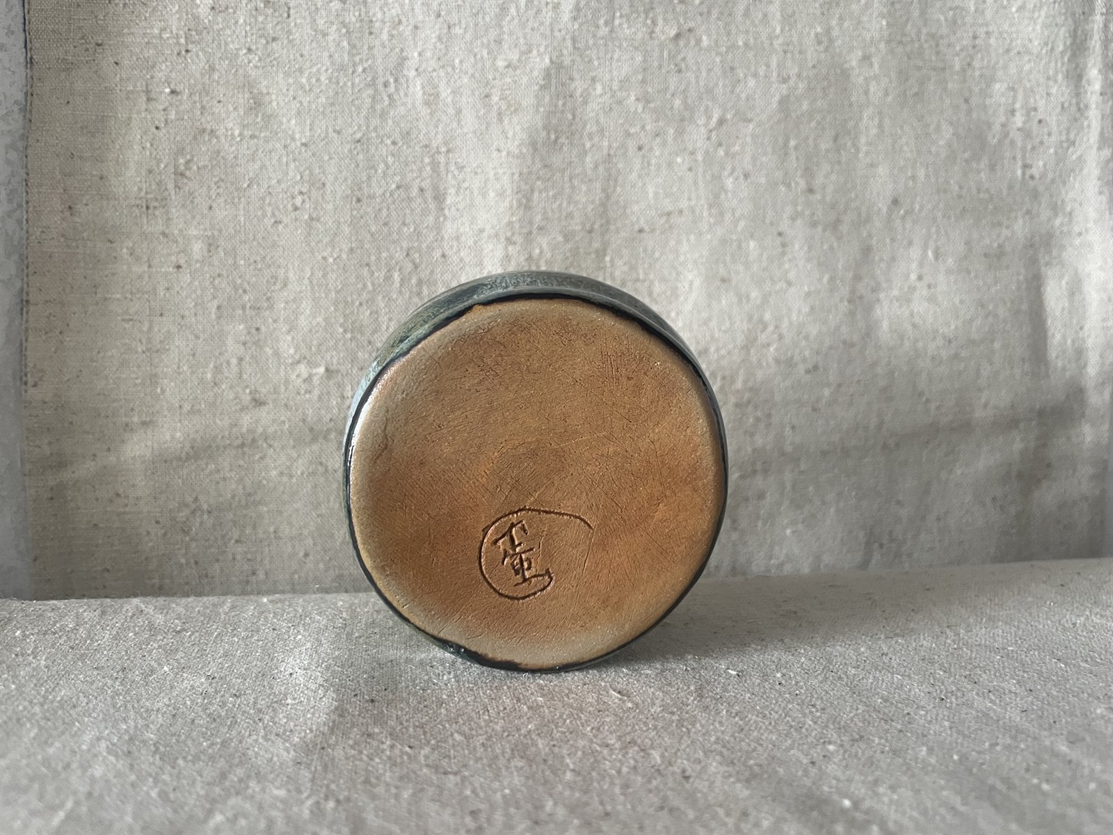 Deep textured ceramic bowl with iridescent ash glaze surface