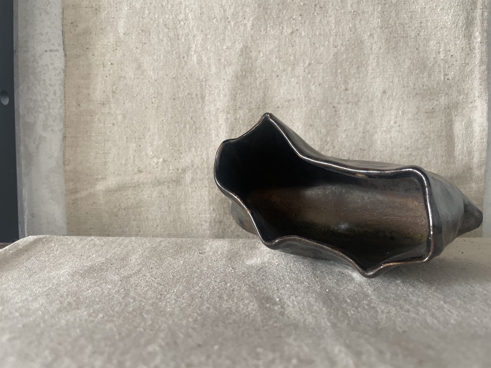 Hand-formed small vessel on raw linen canvas backdrop