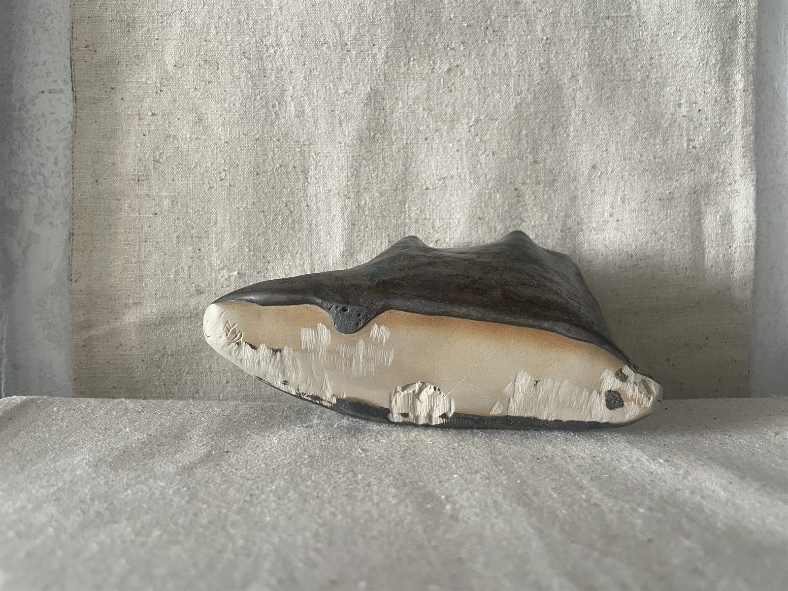 Small round ceramic vessel showing tactile thumb marks and finger tooling