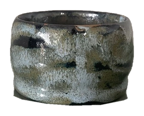 Dark glazed ceramic bowl with pale flowing glaze