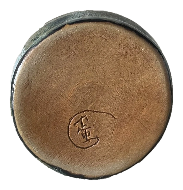 Underside of a circular ceramic bowl with an impressed maker's mark