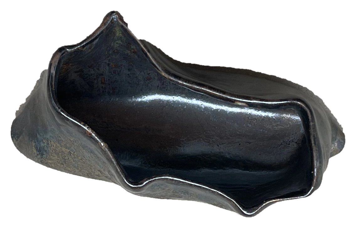 Small dark angular ceramic vessel viewed from above