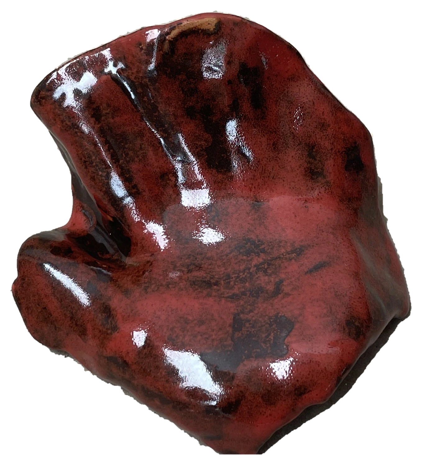 Glossy red hand-shaped ceramic work on a studio floor